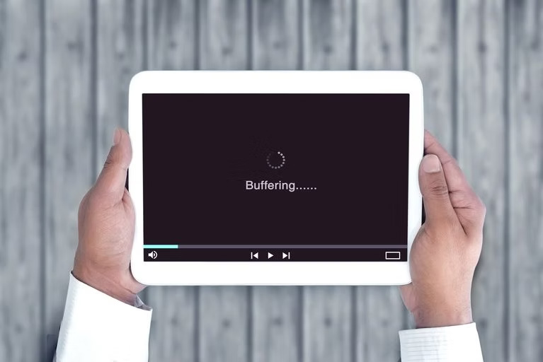 20-2-blog-feature A person holding a tablet with the buffering screen displayed.